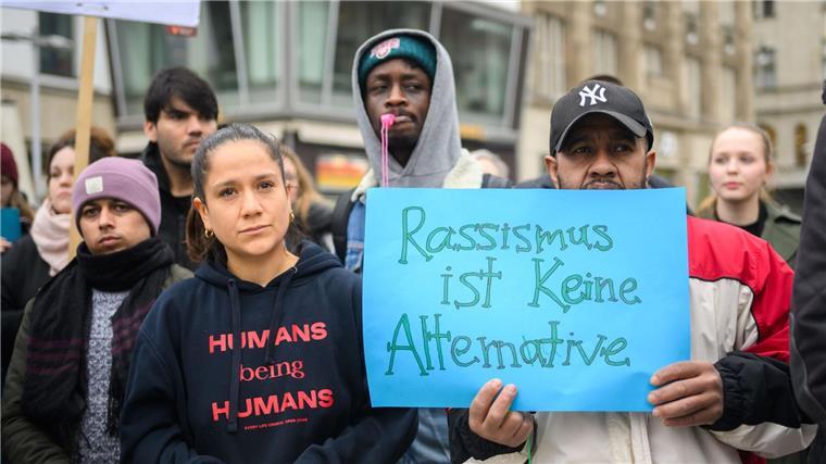 Mit beschrifteten Kleidungsstücken und Schildern demonstrieren Menschen bei einer Veranstaltung am Kröpke.