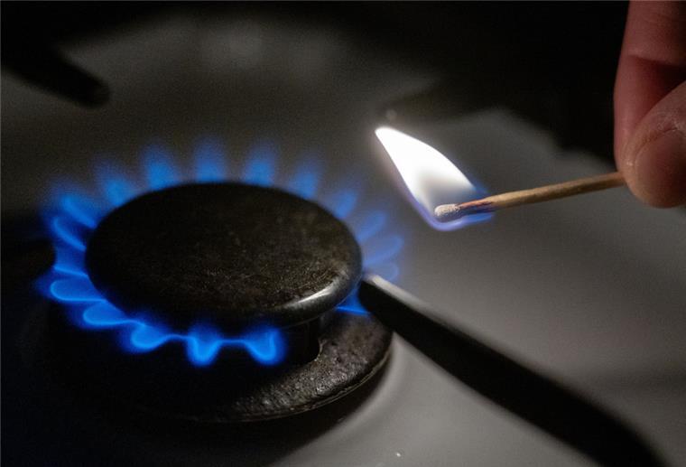 Niedersachsen: Preise für Strom und Gas steigen zum Jahreswechsel Eine Gasflamme wird auf einem Küchenherd mit einem Streichholz entzündet.