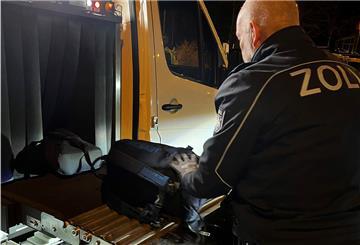 Ein Zollbeamter scannt einen Rucksack