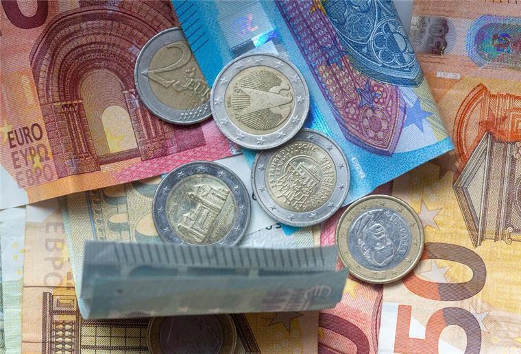 Bares Geld sparen: Mit diesen Tipps ist es möglich Geldscheine und Münzen liegen aufeinander