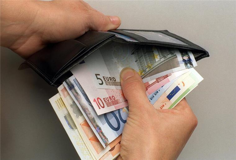 Stromverbrauch zu hoch? Mit diesen Tipps sparst du bis zu 280 Euro Ein Mann verstaut einige Euro-Geldscheine in seiner Geldbörse.