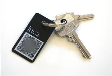 Ein Schlüsselanhänger mit QR-Code und der Aufschrift "luca" liegt auf einem Tisch.