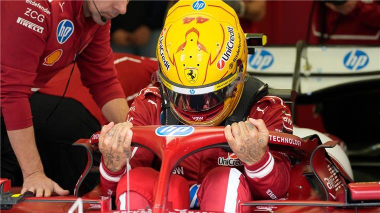 Hamilton und die Last der Ferrari-Liebe Mit gelbem Helm im roten Auto.