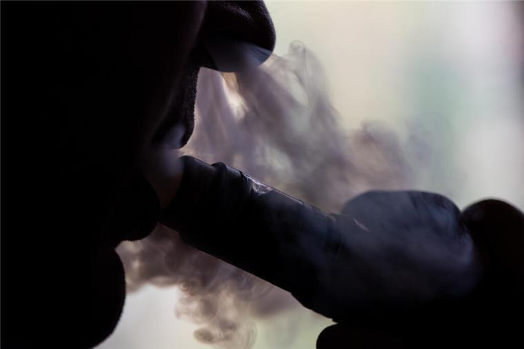 Ein Mann zieht an einer E-Zigarette.  Mit LKWs abtransportiert: Zollfahnder beschlagnahmen in Hamburg tonnenweise illegale E-Zigaretten und 59.000 Euro Bargeld – vier Verdächtige sitzen in U-Haft.
