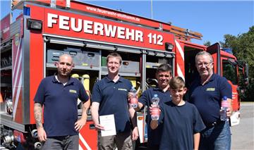 Mit „Löschwasser“ machten die Stollhammer Feuerwehrleute, hier (von links) Malte Tönjes, Markus Felske, Michael Lindloff und Gerd Hennicke auf den Personalmangel aufmerksam. Melvin Lindloff (vorne) steht als Mitglied der Jugendfeuerwehr Eckwarden schon in den Startlöchern.