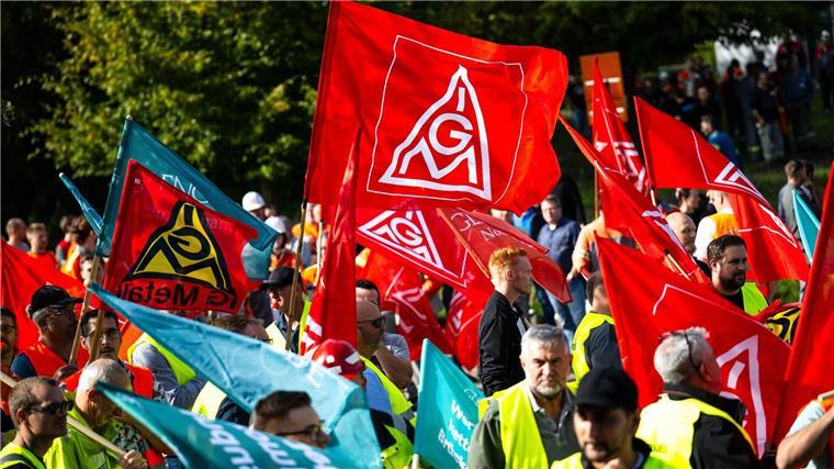 Mit Plakaten und Fahnen stehen die Teilnehmer einer Kundgebung vor der Hauptverwaltung vom Stahlhersteller Arcelormittal.