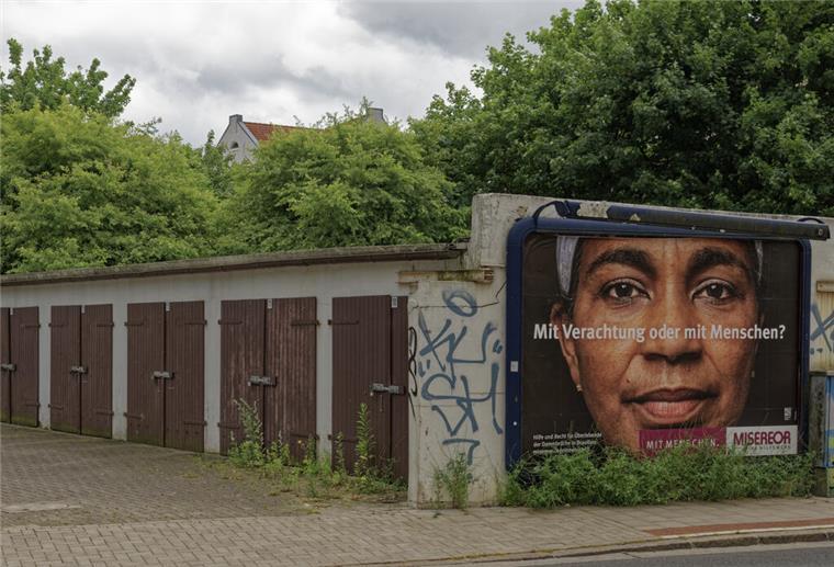 Schöne Bilder von Lehe? Ein Fotograf setzt Stadtteil in Szene "Mit Verachtung oder mit Menschen?" Ein Plakat von Misereor an einem Garagenhof in Lehe, das sinnbildlich für das Kernthema im Blog von Fotograf Thomas Damson steht.
