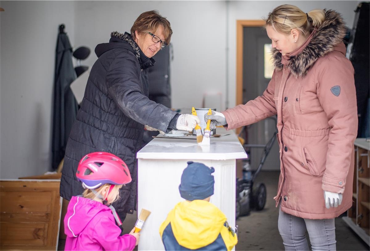 Bauherren machen aus alten Möbeln neue Schätze Mit weißem Holzlack streichen Yvonne Holst, ihre Schwiegermutter Anja Voss sowie die Kinder Fiete und Lotta das gebraucht gekaufte Sideboard, welches später im Wohnzimmer des neuen Hauses Platz finden soll. Foto: Hartmann