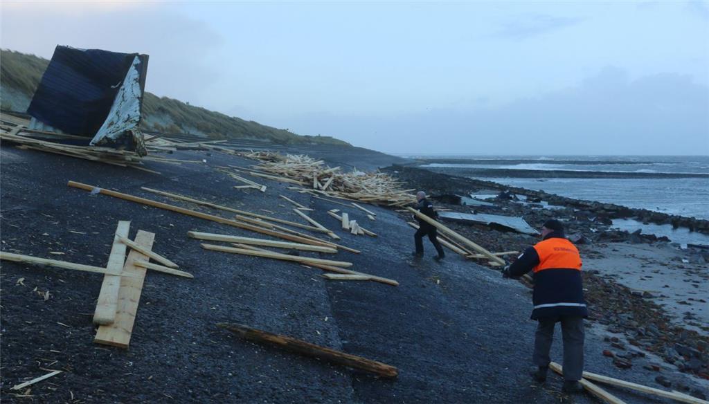Mitarbeieter des Wasser- und Schifffahrtsamts Wilhelmshaven räumen hier am Strand von Wangerooge Ladung und Reste eines im Sturm zerstörten Containers weg.