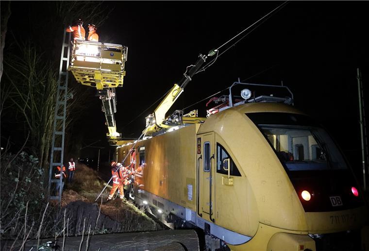 Bahnverkehr läuft immer noch nicht glatt Mitarbeiter der Deutschen Bahn stehen auf einem speziellen Triebfahrzeug zur Instandhaltung von Oberleitungen und reparieren den stromführenden Strang. Durch die Stürme wurde ein Baum umgedrückt, der auf die Oberleitung fiel und diese Reparatur notwendig machte