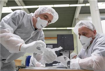 Mitarbeiter der Zender Germany GmbH fertigen Schutzmasken an.