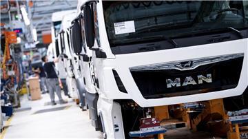 Mitarbeiter von MAN Truck & Bus arbeiten in einer Produktionsstraße.