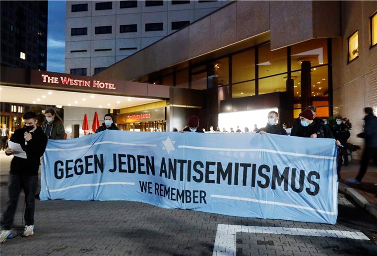 Teilnehmer einer Demonstration des Bündnis "Leipzig nimmt Platz" stehen vor dem «Westin Hotel» Leipzig. 