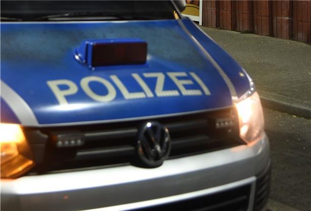 Ein Polizeiwagen steht nachts auf der Straße. 
