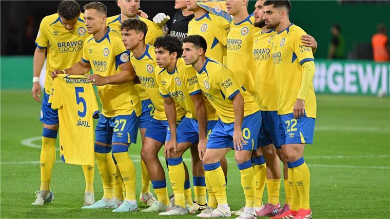 Mitleid mit dem Teamkollegen: Die Braunschweiger halten vor dem Pokalspiel gegen Stuttgart ein Trikot des verletzten Frederik Jäkel hoch. 