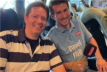 Moderator Daniel Flüß hat sich sein Mikro mit Tape an die Hand geklebt, damit es ihm während der Schussfahrt mit Axel Linneweber nicht aus der Hand gerissen wird.