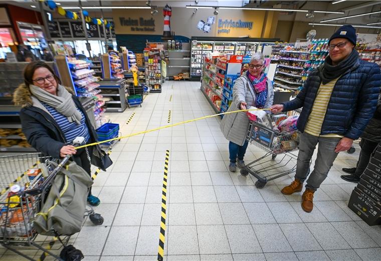 Zwei Meter: Diesen Abstand sollten wir wahren Monika Miesner (links) und Anja Neumann mit Thomas Gries zeigen im E-Center Rotersand, was zwei Meter Abstand im Alltag im Supermarkt bedeuten.