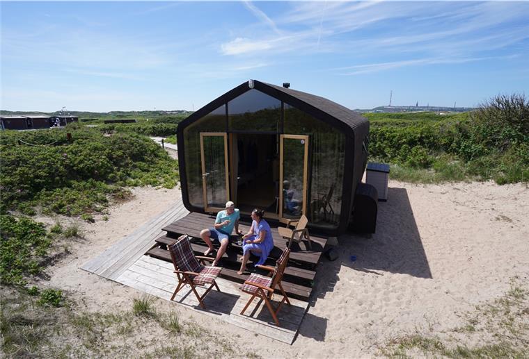 Monique Eichhorn und Sebastian Ebeling, Urlauber aus Berlin, sitzen auf den Stufen ihres Wikkelhouse. Die beiden Wikkelhouses sind für diese Saison ausgebucht.