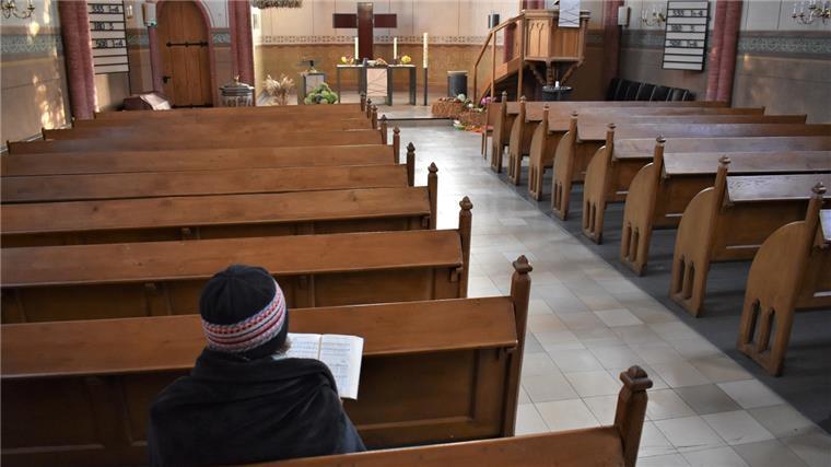 Steigende Energiekosten: Bleiben die Kirchen im Winter kalt? Eine Kirchenbesucherin in St. Jakobi hat sich in eine Wolldecke gehüllt