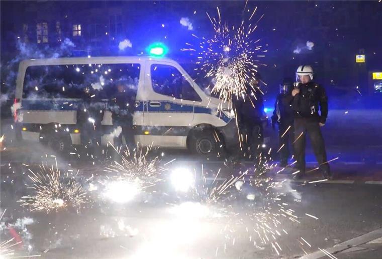 Randale zu Silvester: Debatte um Migranten Polizeibeamte stehen hinter explodierendem Feuerwerk.