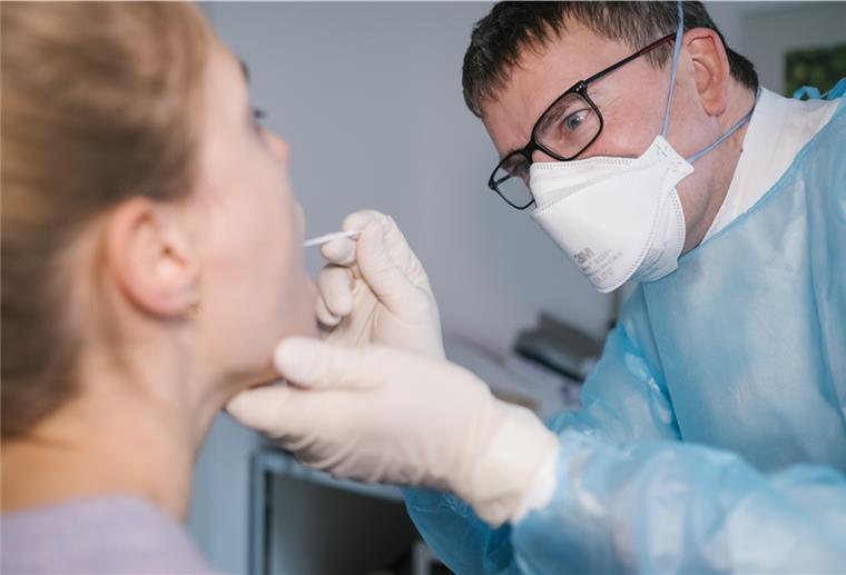 Corona-Fälle bei Frosta Der Facharzt für Allgemeinmedizin, Dr. Matthias Berndt nimmt bei einer Patientin einen Rachenabstrich für einen Covid-19 Schnelltest.