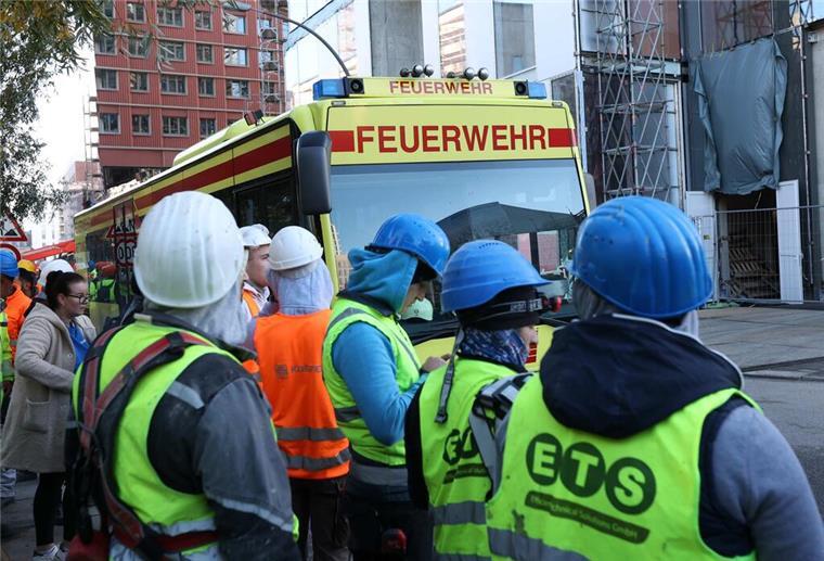 Nach Unfall auf Hamburger Baustelle: Fünfter Arbeiter gestorben Einsatzfahrzeuge der Feuerwehr und Bauarbeiter stehen vor einer Baustelle.