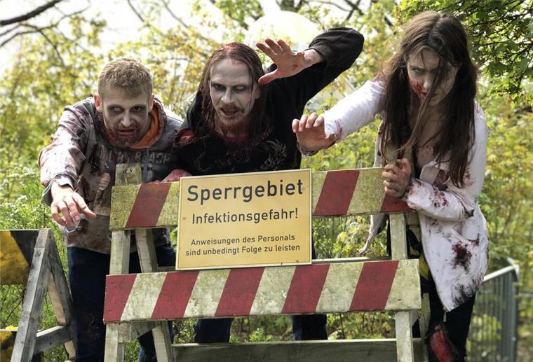 Zombies und Loopings: Heide Park startet in die neue Saison Zombie-Darsteller stehen an einer Absperrung.