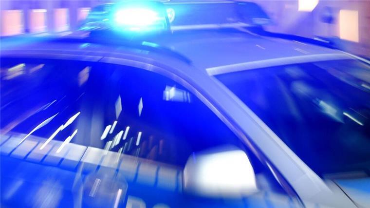 Ein Streifenwagen der Polizei steht mit eingeschaltetem Blaulicht auf der Straße. 