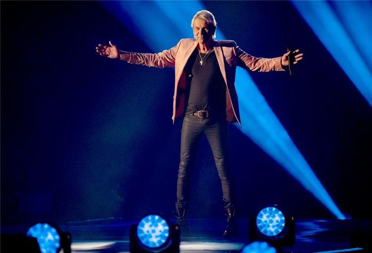 Matthias Reim singt beim "Schlagerbooom 2021 – Alles funkelt! Alles glitzert!". Er steht auf der Bühne und breitet die Arme aus.