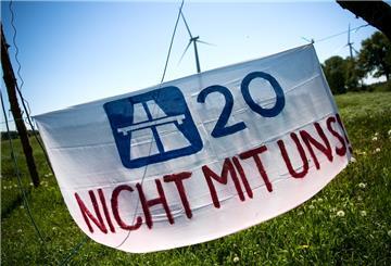 Ein Plakat mit der Aufschrift «A20 Nicht mit uns!» hängt vor einem Protestcamp