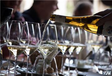 Wein wird aus einer Flasche in Gläser gegossen.