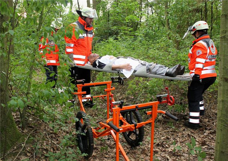 Für den Ernstfall gerüstet: DRK-Einsatzzug Rotenburg übt in Zeven Nachdem ein Suchtrupp die „vermisste Person“ in einem unwegsamen Waldgebiet gefunden hat, wird sie mit einem hochrädrigen Zweirad, das im Fachjargon als „Ho-Chi-Minh-Trage“ bezeichnet wird, geborgen. Die Erstversorgung erfolgt sodann im Rettungswagen, der bei Bedarf von einem Gerätewagen mit Medizintechnik versorgt wird.