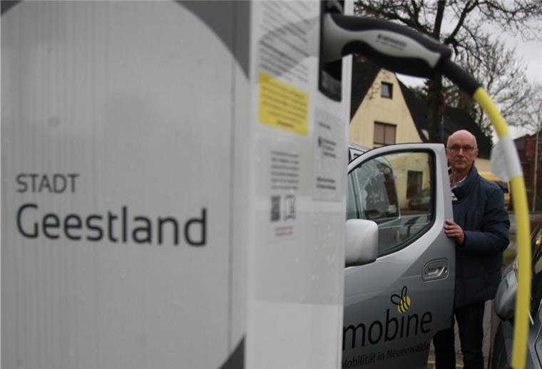 Umweltingenieur empfiehlt batterieelektrisches Auto Ein Mann steht neben einem Auto.