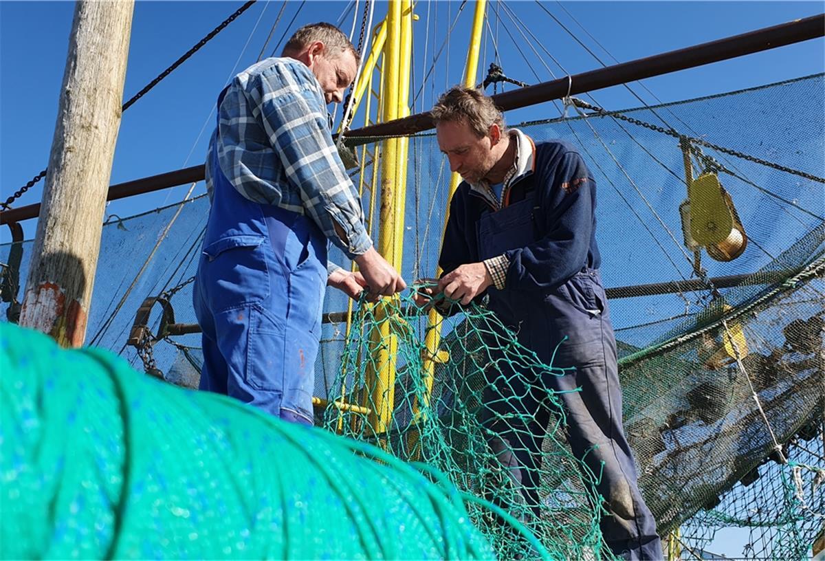 Netze flicken statt Krabben fischen: Die Kutterfischer Stephan (links) und Wolfgang Hellberg in Dorum-Neufeld kämpfen auch mit den wirtschaftlichen Folgen der Corona-Krise.