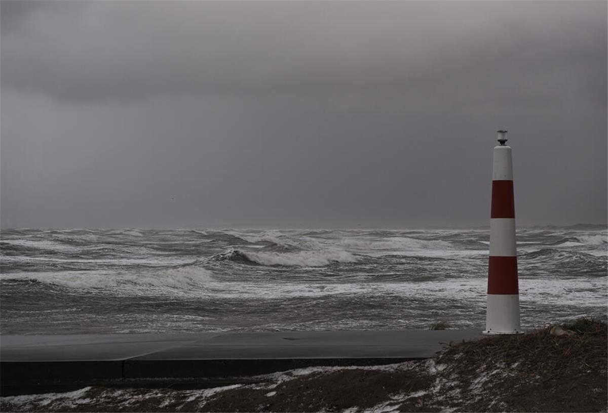 Nordsee, Wellen und rechts ein Leuchtturm. Neue Analysen bestätigen: Der Silverpit-Krater in der Nordsee ist ein Asteroideneinschlag. Der Himmelskörper löste damals eine riesige Welle aus.