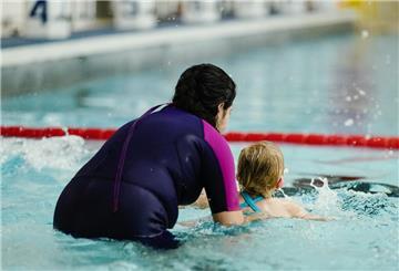 Eine Kursleiterin übt im Schwimmbad des Olympiazentrums bei einem Anfängerschwimmkurs für Kinder des SV Nikar Heidelberg mit Teilnehmerin Leontine.