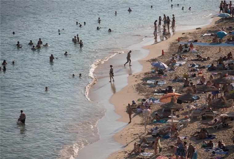 Menschen schwimmen und sonnen sich in Cala Portals auf Mallorca.  Nicht jedes Souvenir ist erlaubt. Exotische Andenken oder Plagiate können bei der Einreise zu Problemen führen. Vorab informieren schützt vor Strafen.