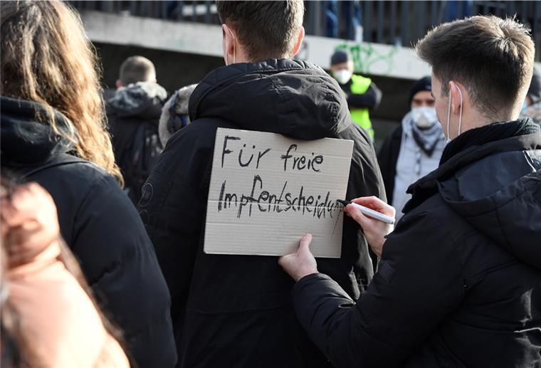 Demonstranten tragen auf Schildern ihren Protest gegen die Massnahmen in der Corona-Pandemie auf die Strasse.