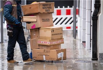 Ein Paketbote liefert Pakete aus.