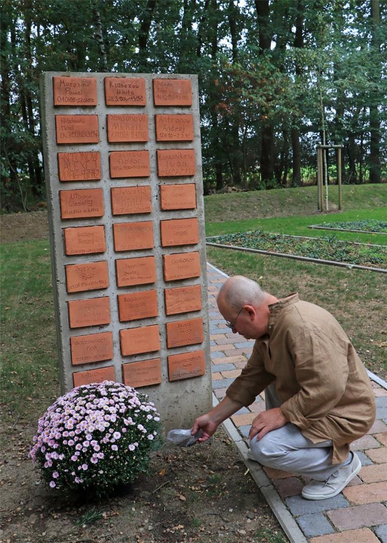 Nikolaj Koloskow trauert in Zeven um seinen Großvater, der in der Muna zu Tode kam. Er hat aus der Heimat Erde mitgebracht, die er an der Stele verstreut.