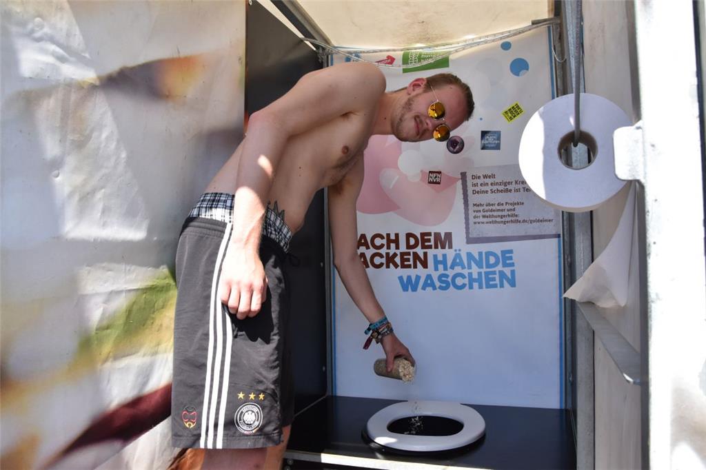 Nils Schäfer von Goldeimer zeigt, wie die Spülung der Klos funktioniert. Die Toiletten veschwenden kein Wasser. Foto: Overschmidt