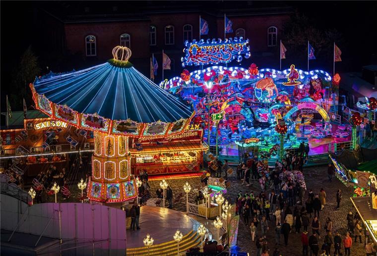 Beleuchtete Karussells am Abend auf dem Freimarkt in Bremen.