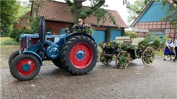 Ein Trecker fährt auf einer Straße entlang. Noch laufen die Vorbereitungen auf das Erntefest, am 4. Oktober geht es dann los, unter anderem mit einem Umzug durchs Dorf.