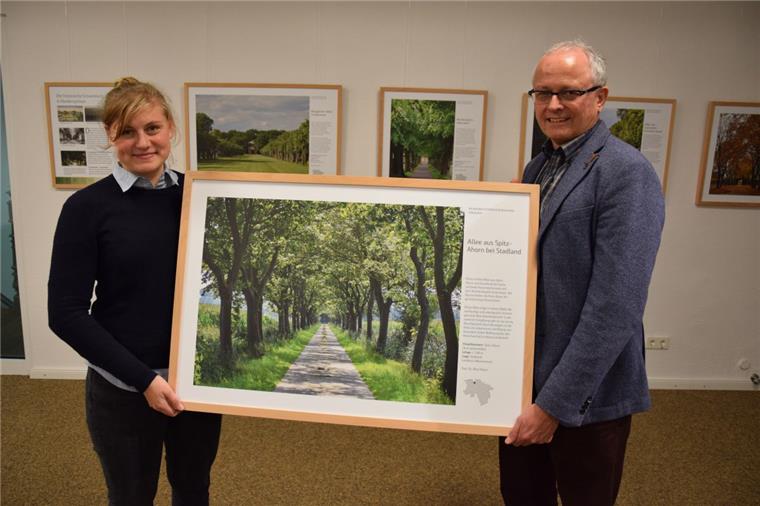 Nora Kraack und Dr. Timothy Saunders präsentieren ein Foto einer Allee in Stadland.