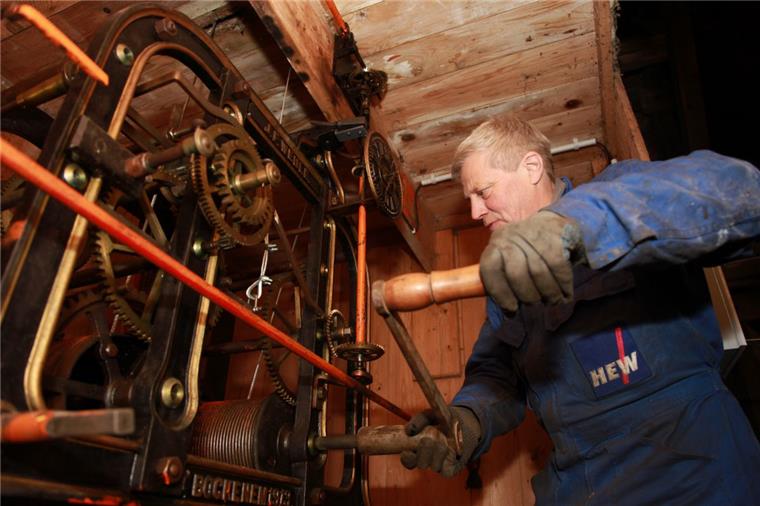 Nostalgisch: Bislang wurde das Uhrwerk der St.-Georg-Kirche mit einer Kurbel einmal pro Woche von Hand aufgedreht. Läutmaschinenmonteur Carsten Weiß demonstriert das Prozedere, das nun Geschichte ist. 