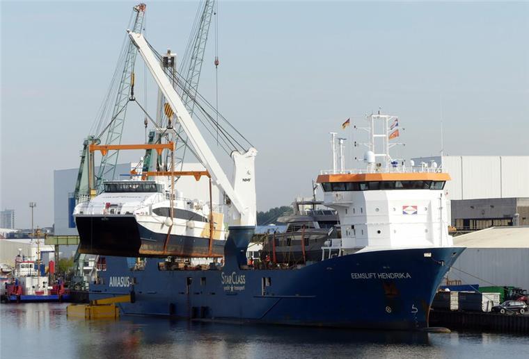 Zukunft der Verbindung ist ungewiss - Helgoland-Katamaran „Adler Jet“ verkauft Ein Katamaran wird mit zwei Kränen eines Schwergutschiffs aus dem Wasser und an Bord angehoben.
