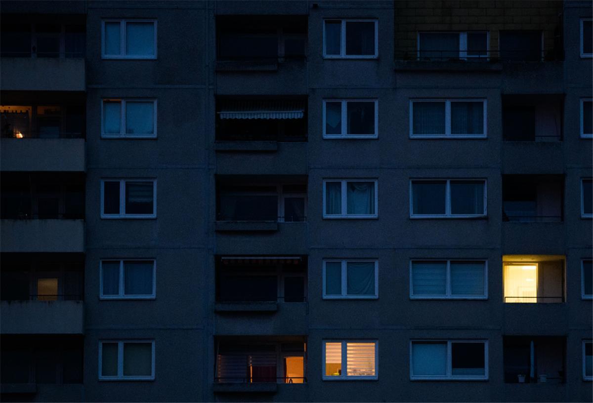 Verbraucherzentrale und DGB Bremen: Gas und Strom nicht abdrehen In einzelnen Wohnungen eines Mehrfamilienhauses brennt am frühen Morgen Licht.
