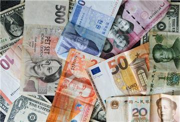 Internationale Währungen liegen auf einem Tisch. Ob am Geldautomaten oder beim Bezahlen im Restaurant: Wer im Ausland auf die richtige Karte und Währung setzt, spart Gebühren – und schont das Urlaubsbudget.