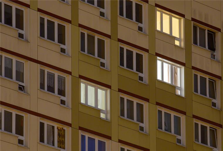 Bremen: Wohngeld plus startet zum neuen Jahr Erste Lichter brennen in den Fenstern eines Wohnhochhauses.
