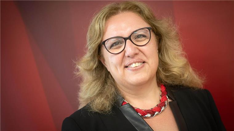 Wieder „Brötchentaste“: 78 Parkautomaten umgestellt Özlem Ünsal (SPD), Senatorin für Bau, Verkehr und Stadtentwicklung, steht vor einer roten Wand.